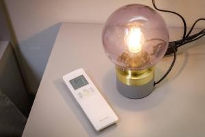 a light on a table with a thermometer and a lamp at Residenza Cavour - Appartamento C in Tirano