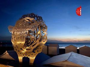 een gouden leeuwenbeeld op het strand 's nachts bij Appartement sur la place du ma in Mers-les-Bains