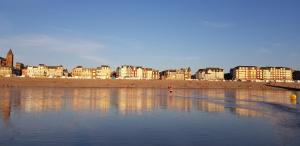een uitzicht op een strand met gebouwen op de achtergrond bij Appartement sur la place du ma in Mers-les-Bains
