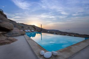 a large swimming pool with a view of the ocean at Mykonos Mint Villa - Sofia in Kalafatis