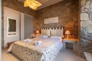 a bedroom with a bed with towels on it at Mykonos Mint Villa - Sofia in Kalafatis +12 photos