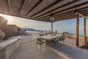 a table and chairs on a patio with a view of the ocean at Mykonos Mint Villa - Sofia in Kalafatis