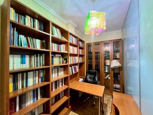 a library with wooden shelves filled with books at Stylish Modern Maisonette in Thessaloniki