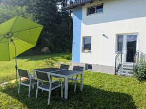 ein Tisch und Stühle mit einem grünen Sonnenschirm in der Unterkunft Stop & Sleep Ybbs in Ybbs an der Donau