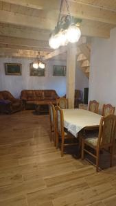 una sala da pranzo con tavolo, sedie e divano di Agroturystyka dzika łąka Słonów Domek 