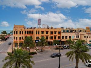 a city street with palm trees in front of a building at بفن للشقق المخدومة Puffin Serviced Apartments in Al Jubail