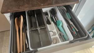 Un cajón lleno de espátulas y otros utensilios de cocina. en Mobile home Lacanau Ocean, en Lacanau