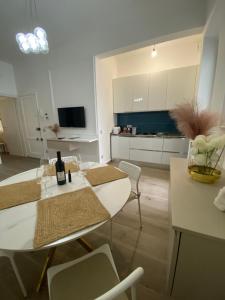 a living room with tables and chairs and a kitchen at Appartamento Olivia in Viareggio
