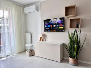 a living room with a white cabinet and a tv on the wall at Apartment Chrzanòw in Chrzanów +30 photos