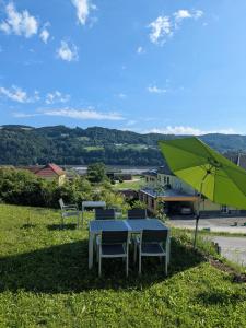 einen Tisch, zwei Stühle und einen grünen Regenschirm in der Unterkunft Stop & Sleep Ybbs in Ybbs an der Donau