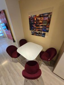 a white table and four chairs with red seats at Apartment Vodni with parking in Brno +19 photos