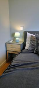 Una cama con mesita de noche con una lámpara. en White Design Apartment, en Aveiro