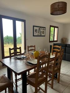 a dining room with a wooden table and chairs at Maison avec verger in Azerat