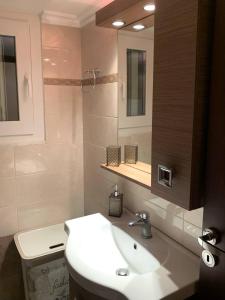a bathroom with a sink and a toilet and a mirror at Maria's House in Karpathos +18 photos