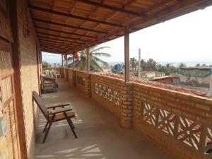 - un balcon avec un banc et une table dans un bâtiment dans l'établissement Pousada Sol e Mar, à Parajuru