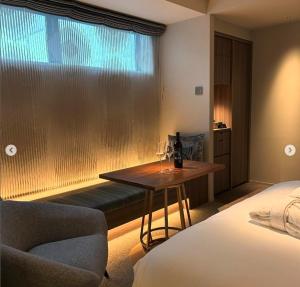 a hotel room with a table and a couch and a window at THE skM TOKYO HOTEL & DINING in Tokyo