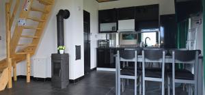 een keuken met zwarte kasten en een bar met krukken bij Domek nad jeziorem Potoczek, Giże in Giże