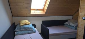 een kleine kamer met twee bedden en een raam bij Domek nad jeziorem Potoczek, Giże in Giże
