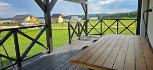 een houten veranda met een houten bank op een terras bij Domek nad jeziorem Potoczek, Giże in Giże +9 foto's