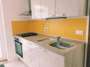a kitchen with a sink and a stove at Active Apartments Koper in Koper