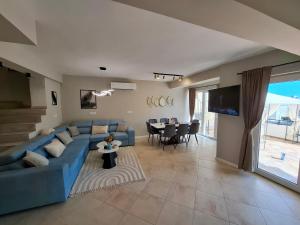 a living room with a blue couch and a table at Marina Elegance Apartments in Balchik