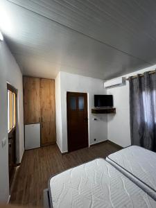 an empty room with a bed and a tv at Vokopola Villa in Sarandë