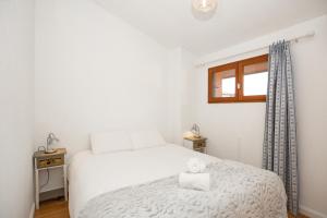 een slaapkamer met een wit bed en een raam bij Atlantic Selection - La Villa Senda à Capbreton in Capbreton