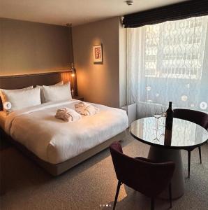 a bedroom with a large bed and a table at THE skM TOKYO HOTEL & DINING in Tokyo