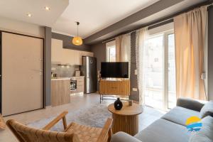 a living room with a couch and a tv at Pame Rentals - 2BD Modern Home Steps from Pasalimani in Piraeus