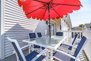 a patio table and chairs with a red umbrella at Beach Villa in Old Orchard Beach