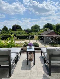 a patio with two benches and a table with flowers at The Loft in Melsele