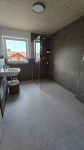 a large bathroom with a shower and a sink at Quiet Room with Balcony in Peißenberg