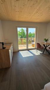a living room with a large window and a table at Quiet Room with Balcony in Peißenberg