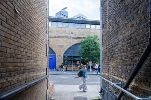 a woman walking down a street between two brick walls at London Bridge Stays in London
