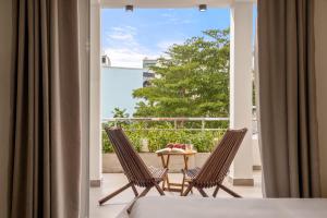 a room with two chairs and a table on a balcony at Aurora Villa - Near My Khe Beach & City Center by The Key in Da Nang