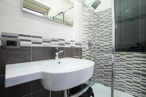 a bathroom with a white sink and a mirror at Monte Monaco B&B in San Vito lo Capo