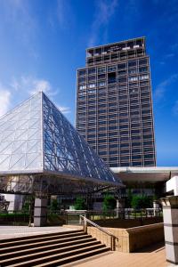 ein großes Glasgebäude mit einer Treppe davor in der Unterkunft Hotel Monterey Grasmere Osaka in Osaka