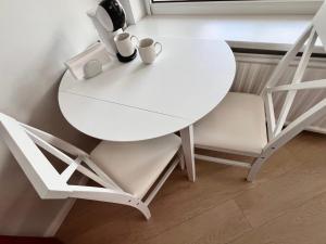 a white table and chairs in a room at Apartamentai Vanagupės banga in Palanga
