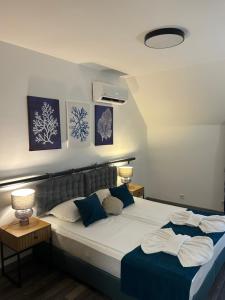 a bedroom with a large bed with blue pillows at Апартаменти Лилия 2 in Primorsko