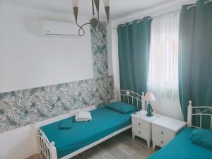 a bedroom with two beds and a window at Aquamarine in Voroklini