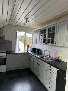 a kitchen with white cabinets and a sink at KSU Topleiligheten in Kristiansund +30 photos