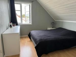a bedroom with a bed and a window at KSU Topleiligheten in Kristiansund