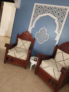 twee stoelen in een kamer met een wolk op de muur bij Appartement avec Terrasse in Larache +32 foto's