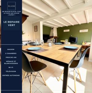 a dining room with a large wooden table and chairs at Le Repaire Vert - Cozy 2 bedroom house in Marck