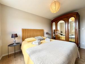 a bedroom with a large bed and a mirror at Le Repaire Vert - Cozy 2 bedroom house in Marck