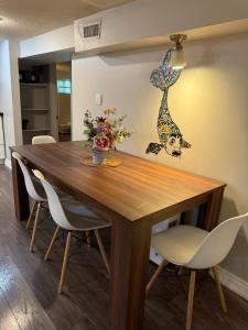 un tavolo da pranzo con sedie e un vaso con fiori di NORTH TORONTO - 2 Bdrm With WiFi and Parking near Yonge St a Toronto