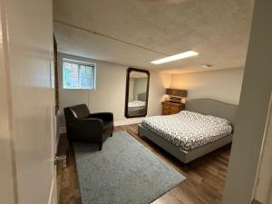 una camera da letto con un letto, una sedia e uno specchio di NORTH TORONTO - 2 Bdrm With WiFi and Parking near Yonge St a Toronto