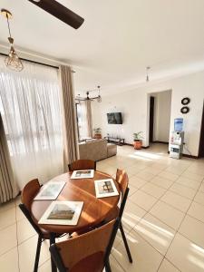 a living room with a wooden table and chairs at Seville Stays Cozy Getaway in Mombasa