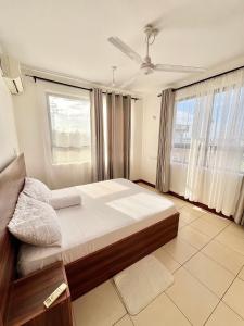 a bedroom with a bed and a large window at Seville Stays Cozy Getaway in Mombasa