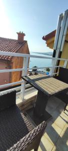 a chair and a table on a balcony with the ocean at GRAND - Beachfront Rooms & Apartments in Selce